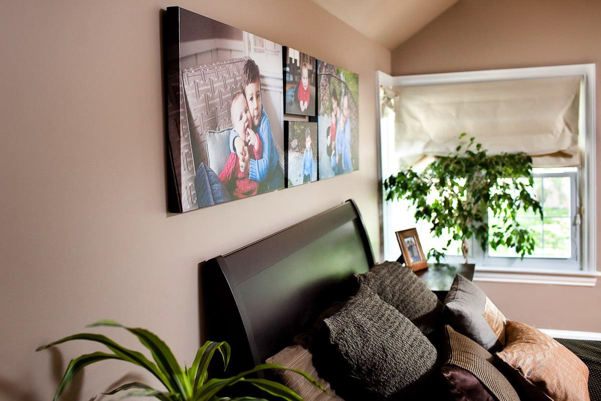 A large wall of pictures hanging on the wall displayed above the headboard in bedroom of parents.