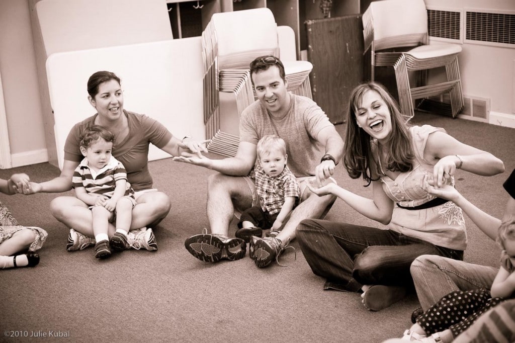 JK_100515_Miss_Amy_033_web_03 A group of people sitting in a circle on the floor holding hands for baby and me music class