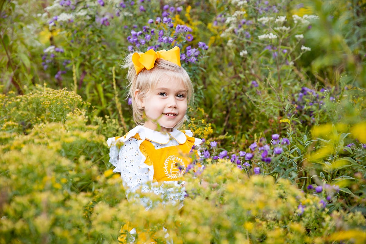 Little girl stands in a field of wildflowers for fall photo shoot at Meadlowlark Botanical Gardens in Vienna, VA