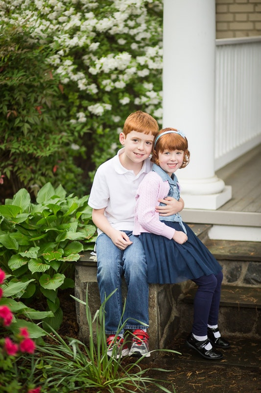 brother and sister sit together outside their home for Washington DC family photography session by Julie Kubal