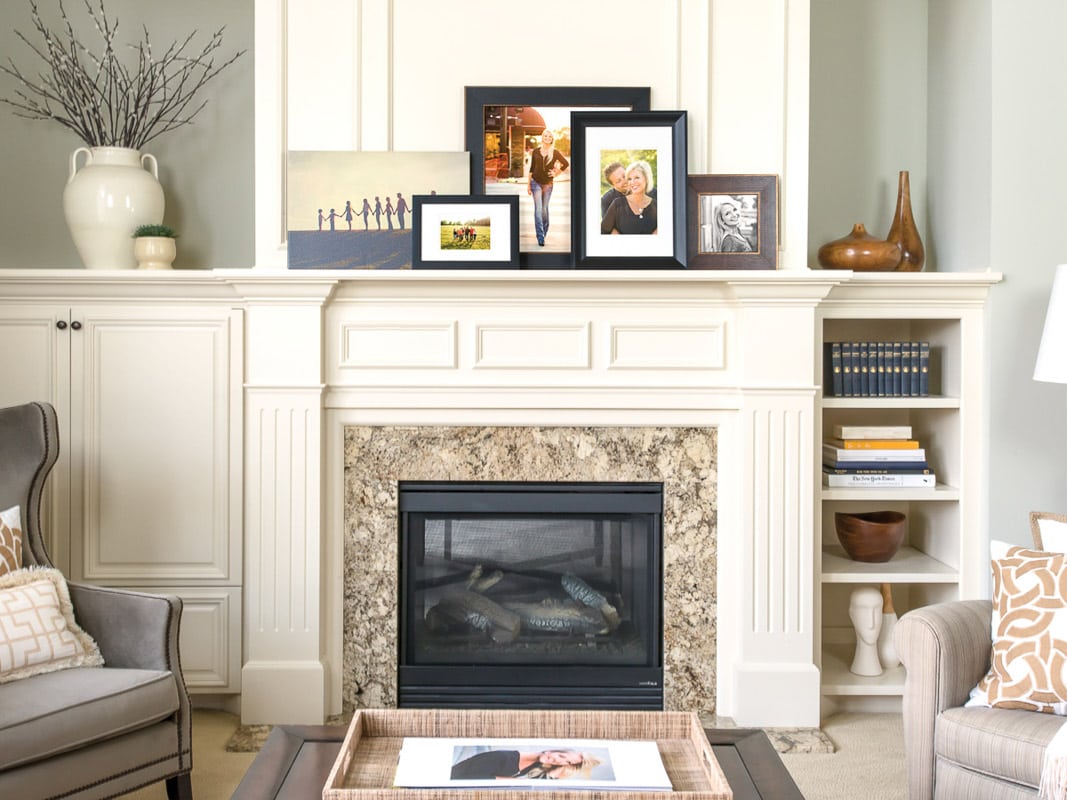 A mix of frame colors and sizes arranged on a fireplace mantle make an effective and creative display of family photos.