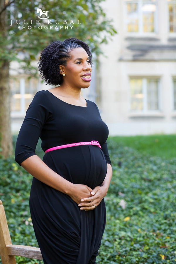 Pregnant woman poses outside on the grounds of Washington National Cathedral by Julie Kubal. Maternity photos taken during family session.